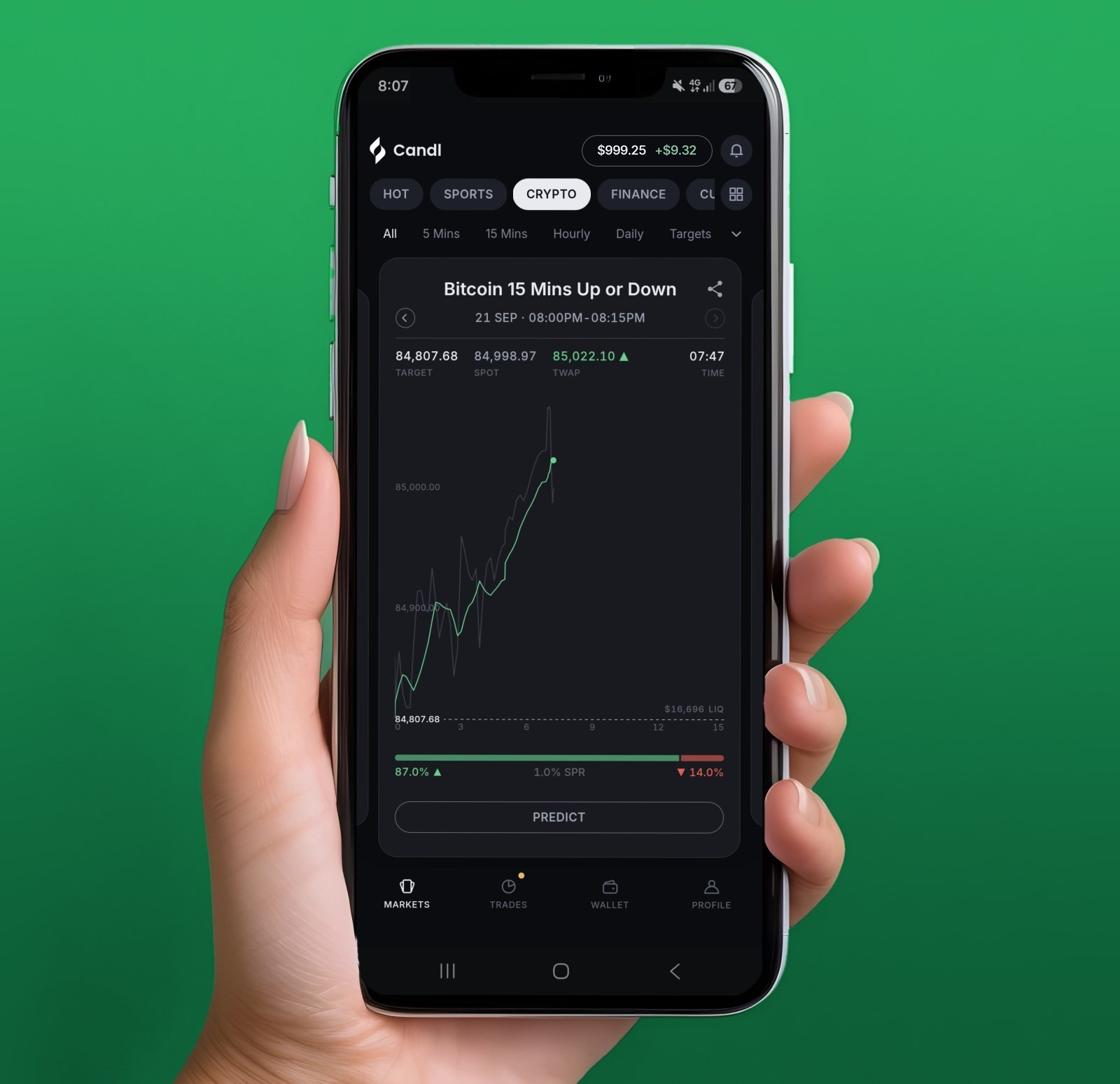 A hand holding a phone running Candl, showing the Bitcoin 15 Mins Up or Down market with a live price chart and a Predict button